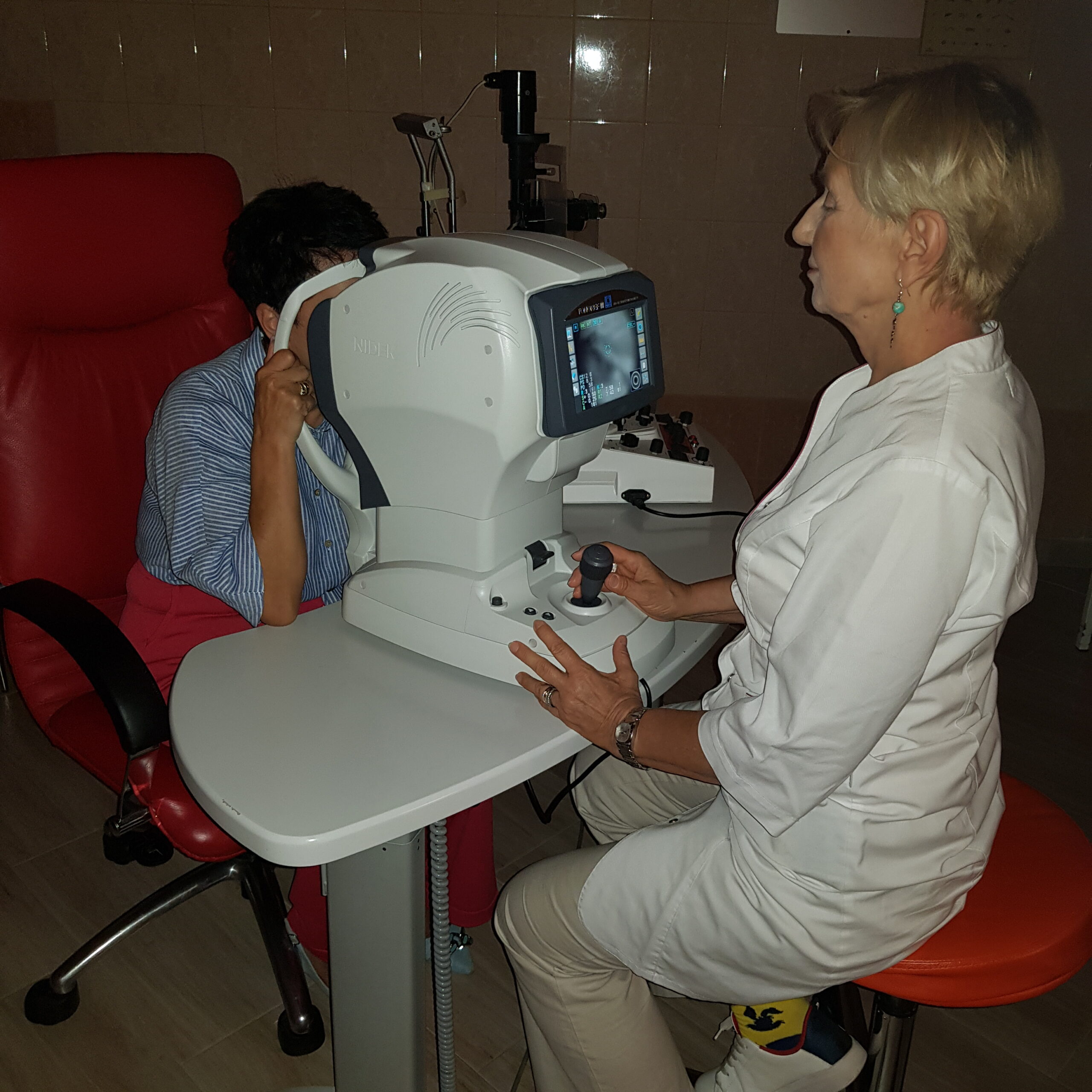 Okulista w Tarnowie wykonuje komputerowe badanie wzroku przy użyciu nowoczesnego autorefraktometru.